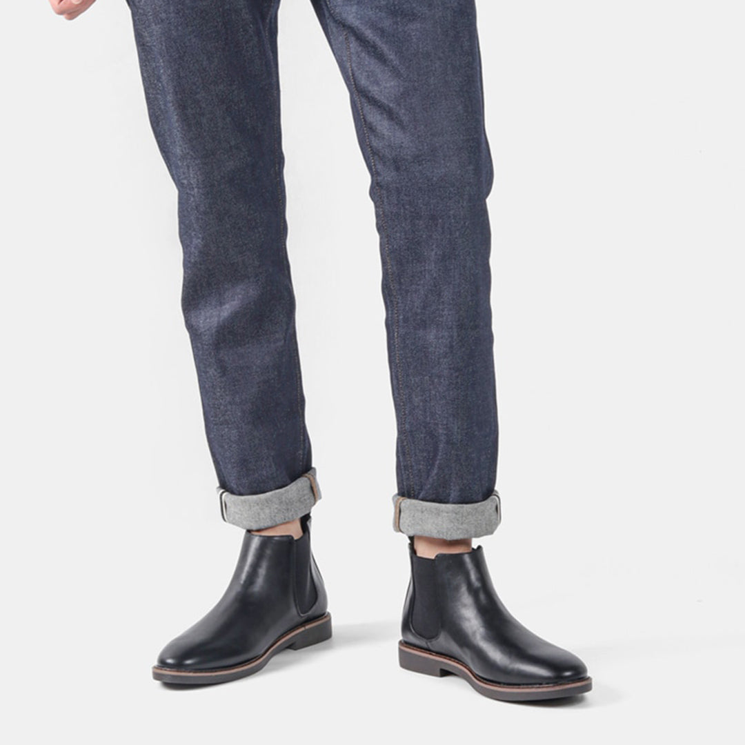 Een man die heren Chelsea laarzen draagt, gecombineerd met een netjes gestylde broek, toont de veelzijdigheid van de schoenen.