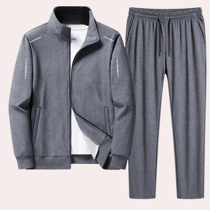Grijze heren trainingspak Owen van zacht polyester, comfortabel en stijlvol. Geschikt als joggingspak en huispak.
