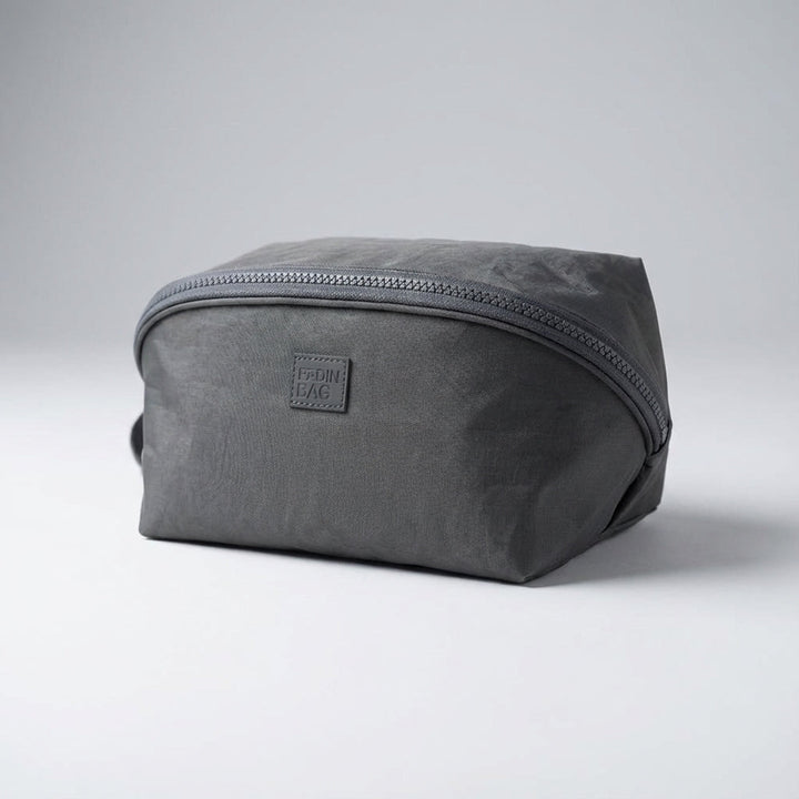 Packify toilettas, compacte reisorganizer met handige vakken voor dames en heren, verkrijgbaar in grijs en roze.