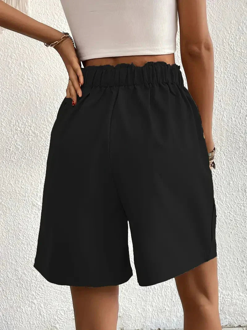 Model draagt zwarte high waist shorts met zomertop