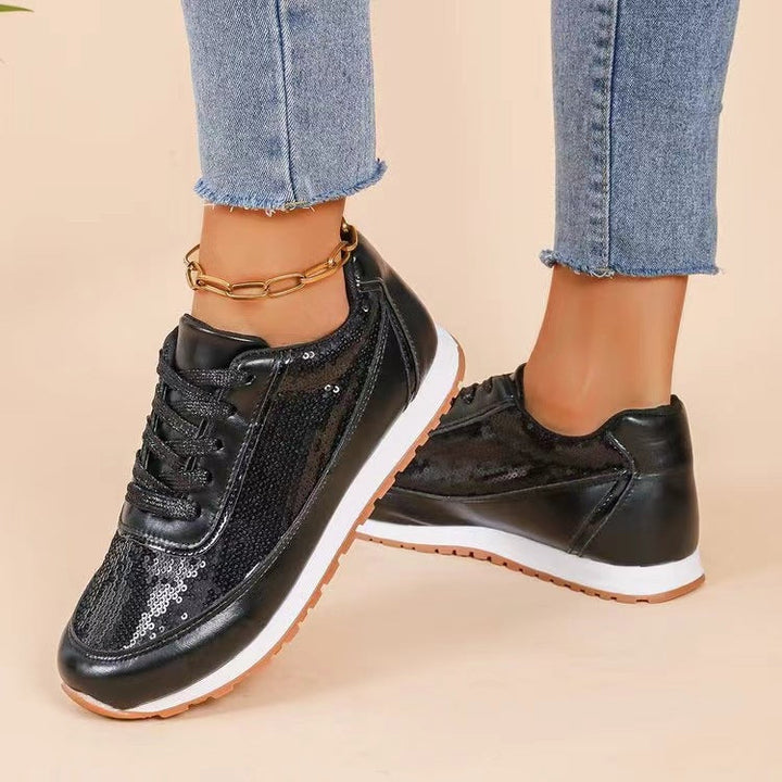 Zijkant van dames sneaker met glanzend bovenwerk en profielzool