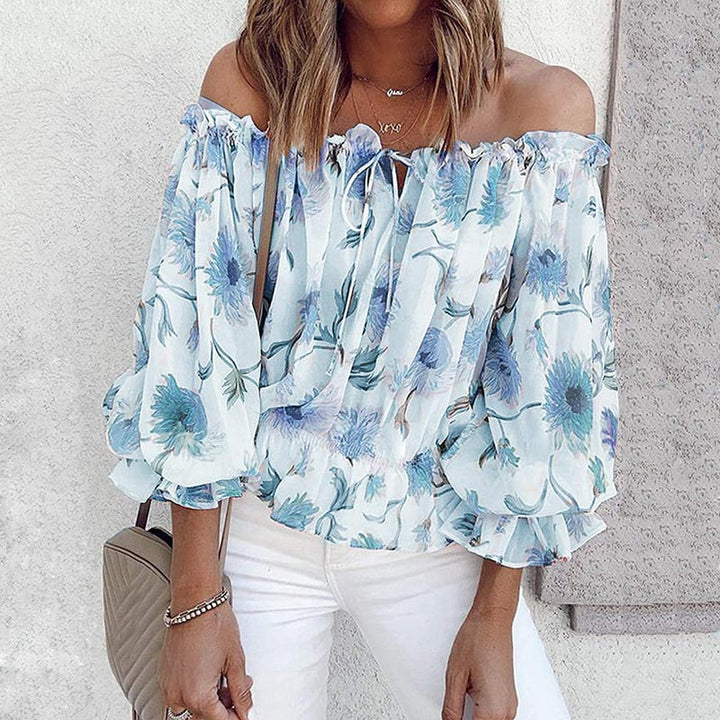 Vrouwelijke damesblouse met bloemenprint en chique ruches mouwen. Ideaal voor een zomerse, luchtige look.