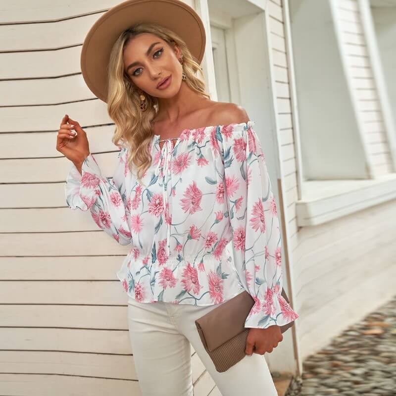 Stijlvolle dames blouse met bloemenprint en ruches mouwen, getoond op model. Complete lente/zomer outfit inspiratie.