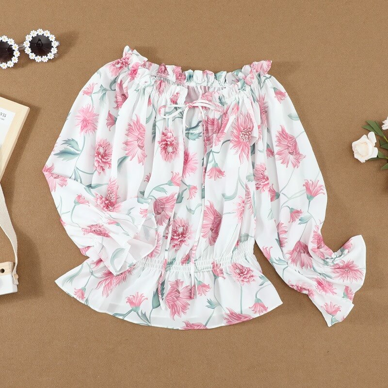 Close-up van de delicate bloemenprint en elegante ruches mouwen op deze vrouwelijke dames chiffon blouse.