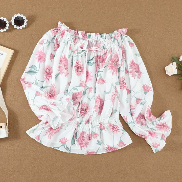 Close-up van de delicate bloemenprint en elegante ruches mouwen op deze vrouwelijke dames chiffon blouse.