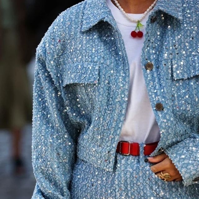 Trendy tweedelige dames denim set met spijkerjack en bijpassende shorts, versierd met pailletten.