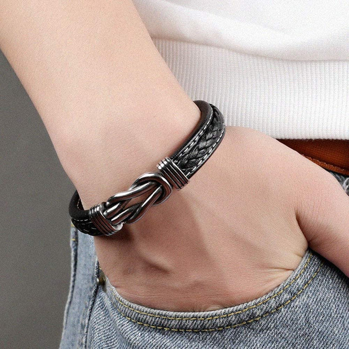 Onmisbaar accessoire: zwarte lederen infinity knoop armband voor dames, stijlvol en eenvoudig te dragen.