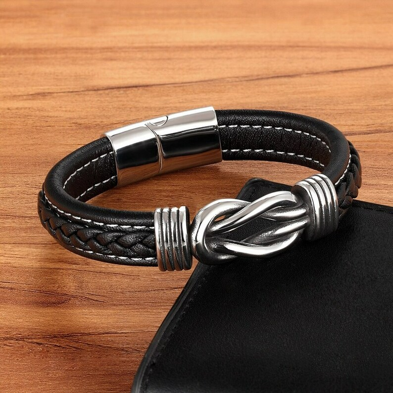 Zwarte infinity lederen armband voor dames, handgemaakt met knoopdetails en veilige magnetische sluiting, modieus sieraad.