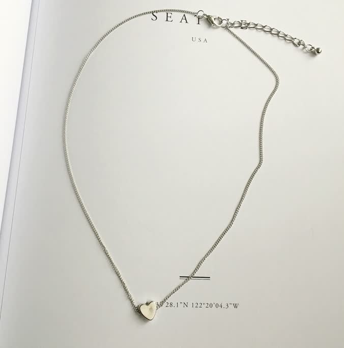 Model draagt gouden dames ketting met hartje om de hals. Elegant en subtiel mode accessoire.