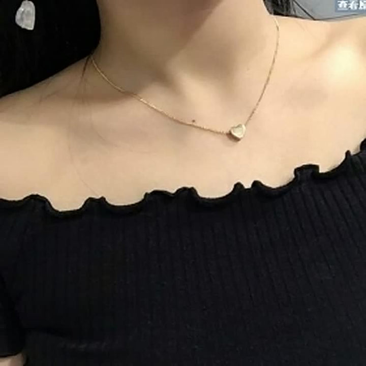 Detail van fijne schakel ketting met zilveren hartje. Delicaat en elegant dames sieraad accessoire.