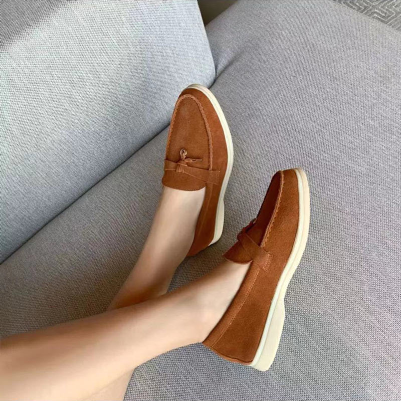 Close-up zwarte dames loafers, gepunte teen & zacht materiaal. Elegante platte slip-on schoenen voor vrouwen.