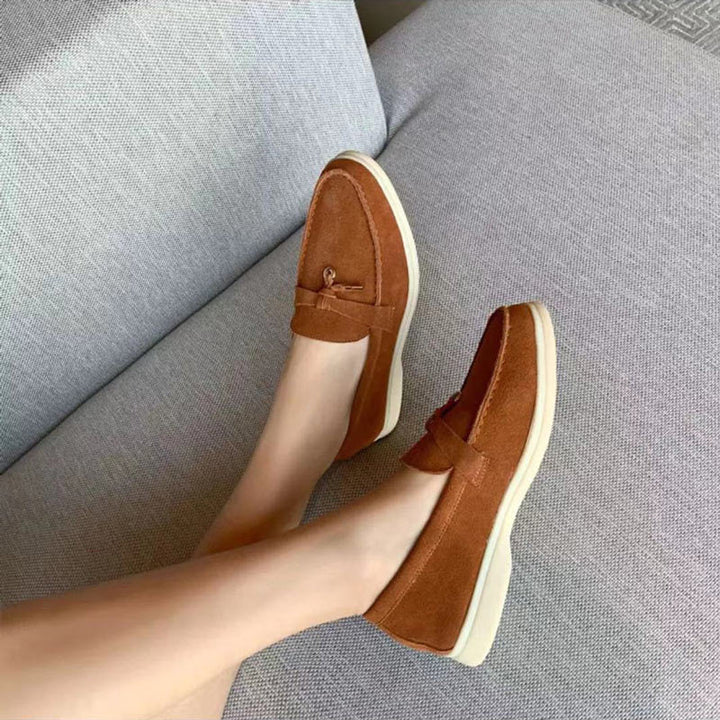 Close-up zwarte dames loafers, gepunte teen & zacht materiaal. Elegante platte slip-on schoenen voor vrouwen.