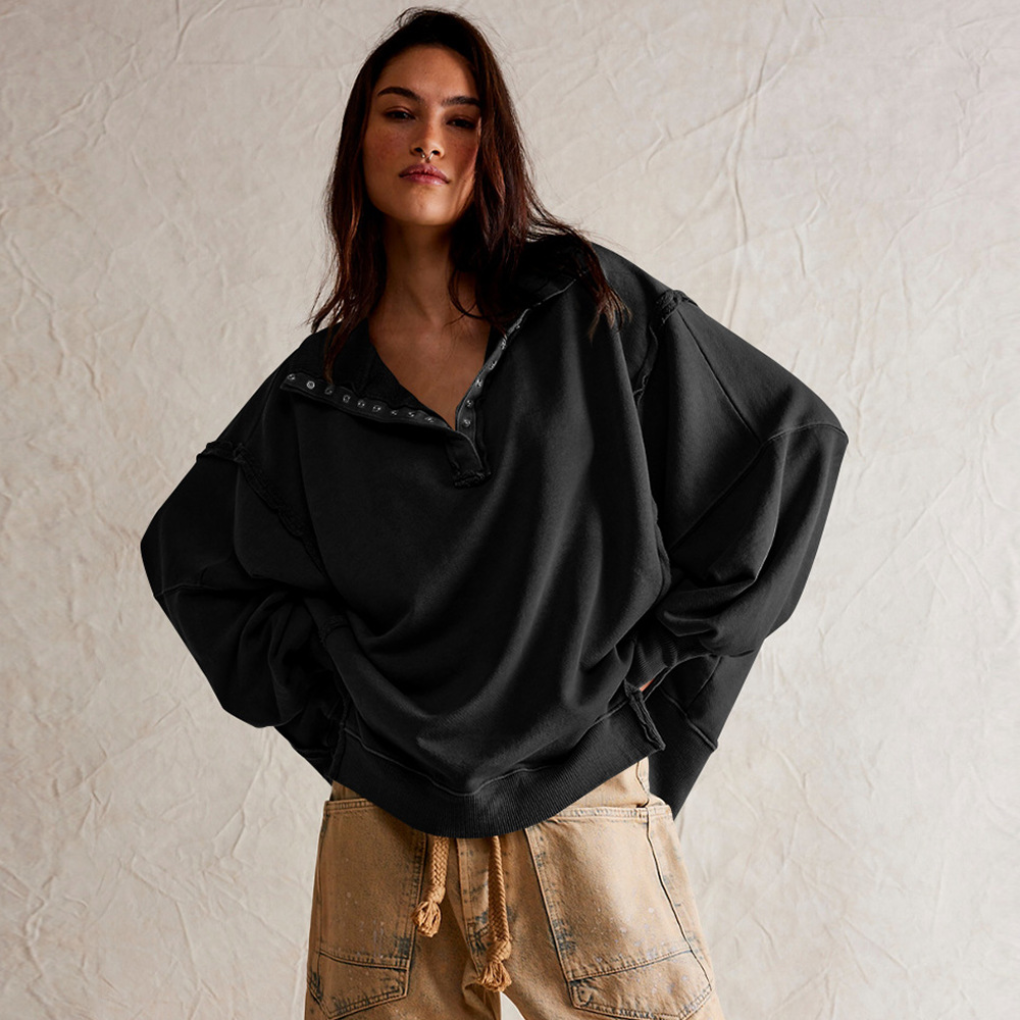 Model draagt casual dames oversized Henley trui met hoog-laag zoom; comfortabel en modieus voor dagelijks gebruik.