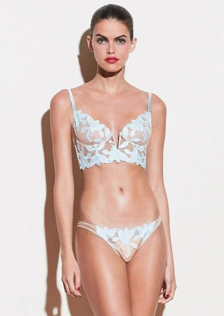 Model toont sexy Franse kant lingerie set; bh met diepe V-hals en bijpassende slip.