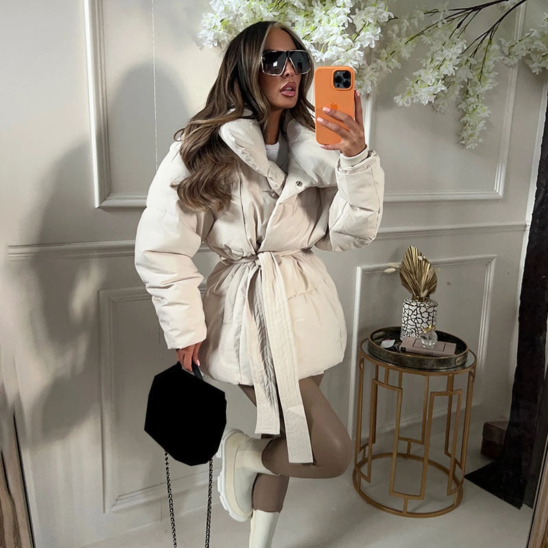 Dikke beige dames winterjas met riem, ideaal voor een warme en stijlvolle winterlook. Elegante lange outwear.