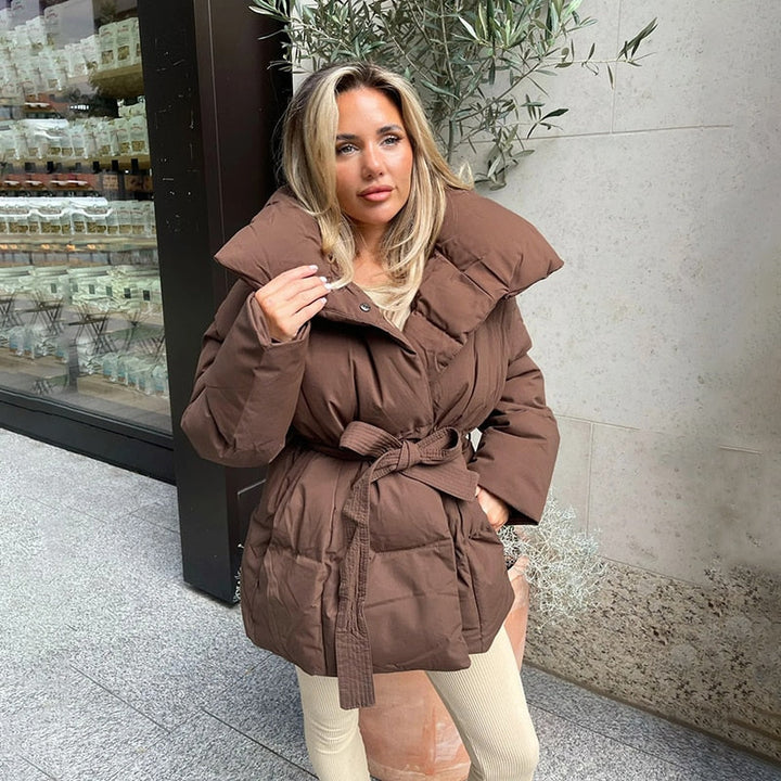 Zwarte modieuze dikke dames winterjas met riem; een warme en elegante jas voor de wintercollectie.