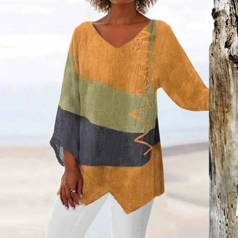 Zijaanzicht van de driekleurige damesblouse met lange mouwen, color block patroon.
