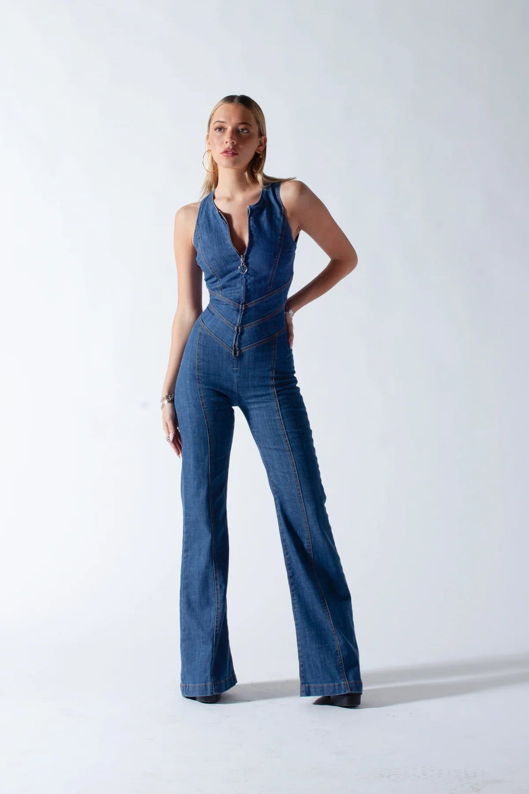 Donkerblauwe dames denim overall, mouwloos, met hartvormige open rug en vintage charme, tegen een witte achtergrond.