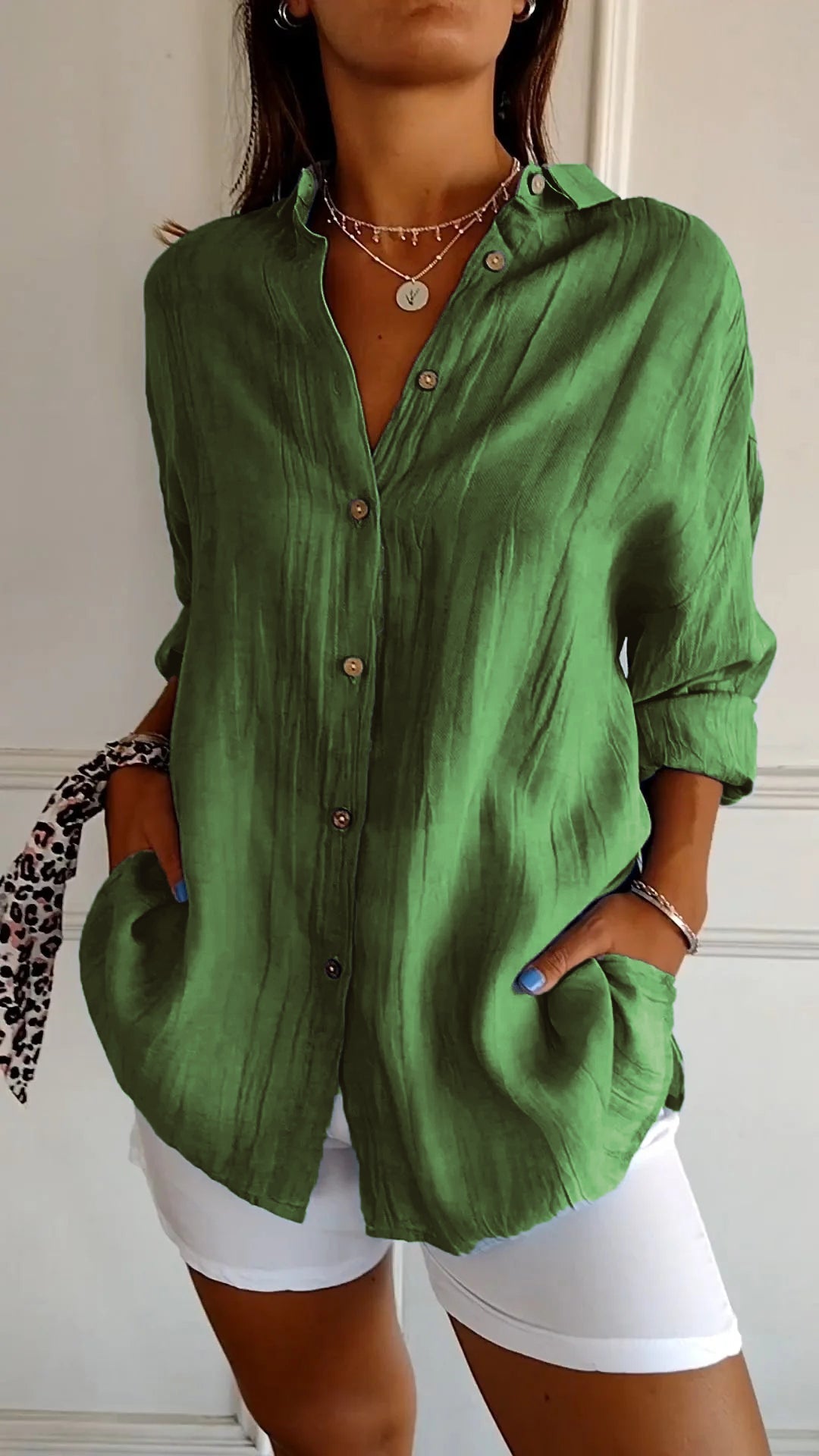 Elegante damesblouse Naya in crème, nauwsluitend en van fijn materiaal voor feestelijke gelegenheden, op een grijze achtergrond.