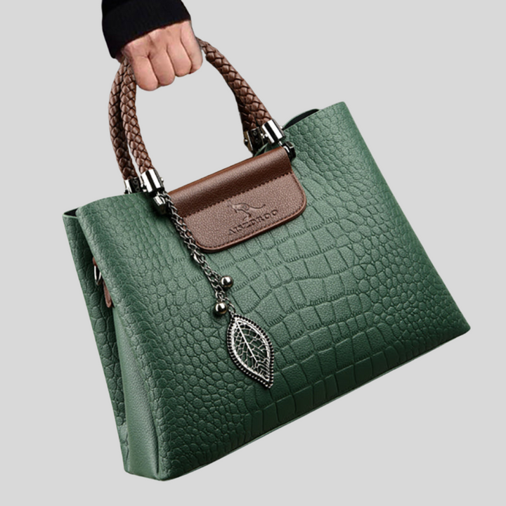 Elegante dameshandtas van leer met verstelbare riem, klassieke vorm, verkrijgbaar in groen en zwart.
