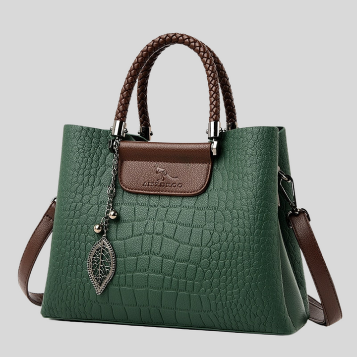Elegante dameshandtas van leer met verstelbare riem, klassieke vorm, verkrijgbaar in groen en zwart.