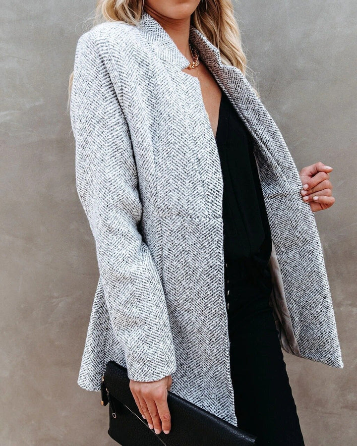 Elegante damesjas in klassiek design, getailleerd, met lange snit en stijlvolle kraag voor veelzijdig gebruik.