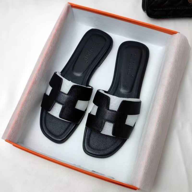 Damesmodel draagt de Hermes geïnspireerde bruine sandalen.