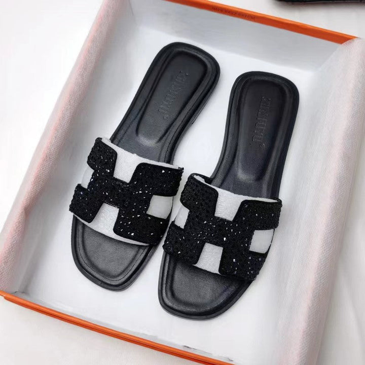 Damesmodel draagt de Hermes geïnspireerde rode sandalen.
