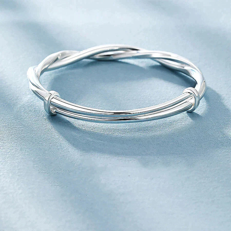 Verstelbare gedraaide zilverkleurige damesarmband, handgemaakt en comfortabel, een elegant accessoire.
