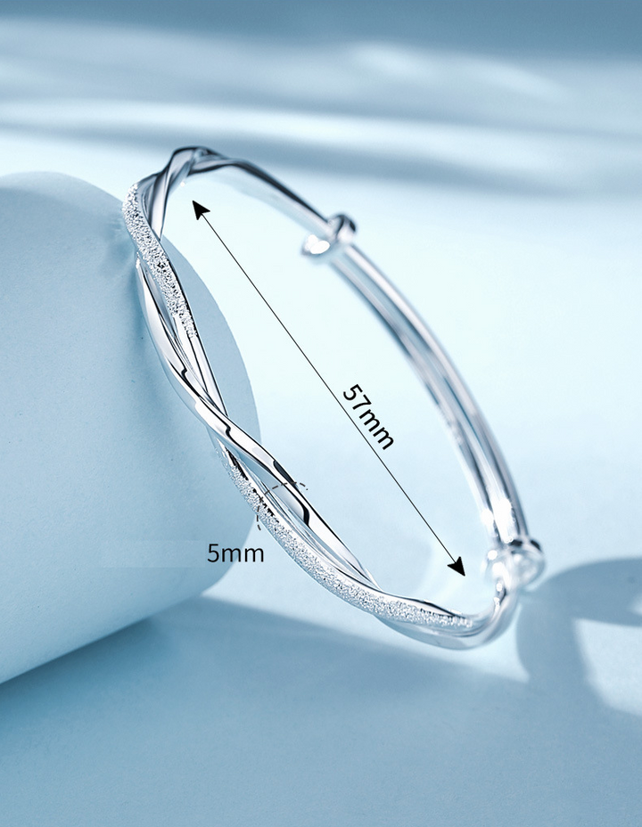 Glanzende zilverkleurige gedraaide damesarmband, een elegant en tijdloos sieraad dat verstelbaar is.