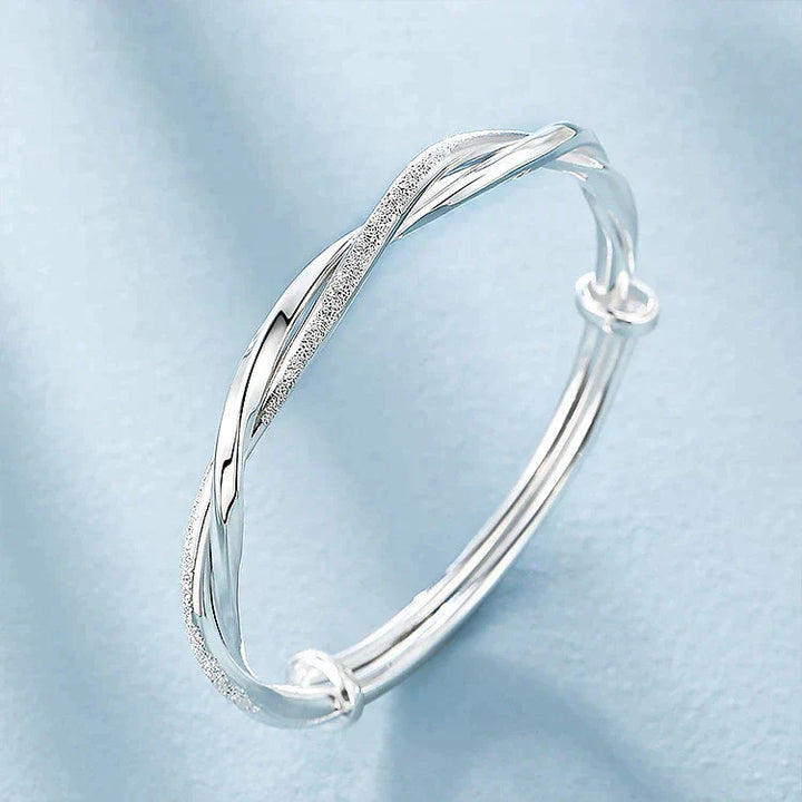Chique gedraaide zilverkleurige armband voor dames, handgemaakt, verstelbaar en een prachtig fashion accessoire.
