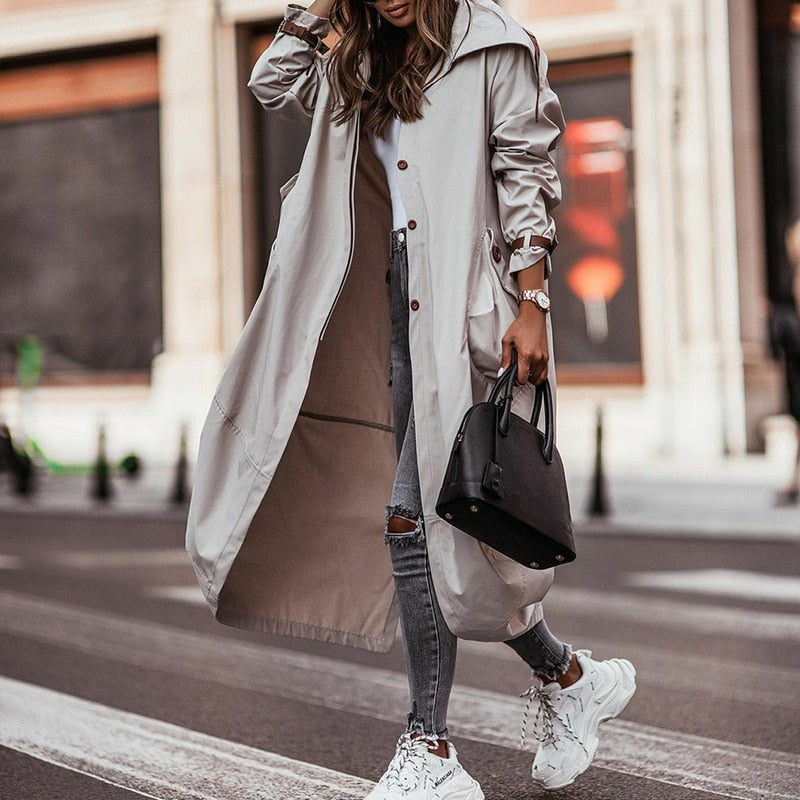 Grijze lange dames trenchcoat met zakken. Veelzijdige bovenkleding, perfect als lente- of herfstjas.