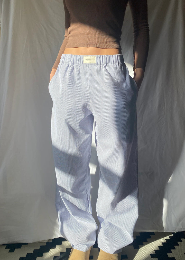 Geconcentreerde afbeelding van gele gestreepte loungebroek, casual en elegant.