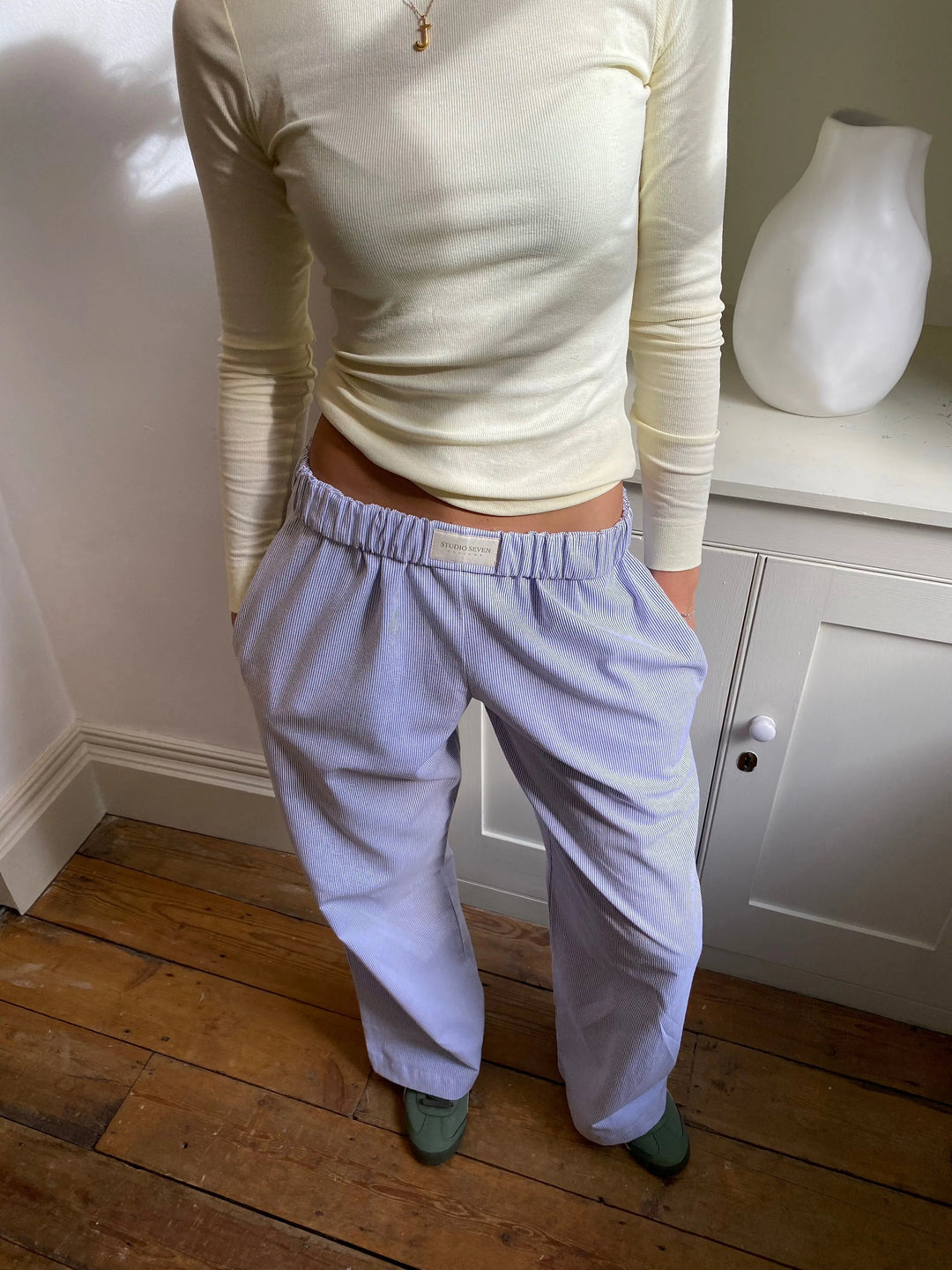 Model draagt de groene gestreepte loungebroek, casual en comfortabel.