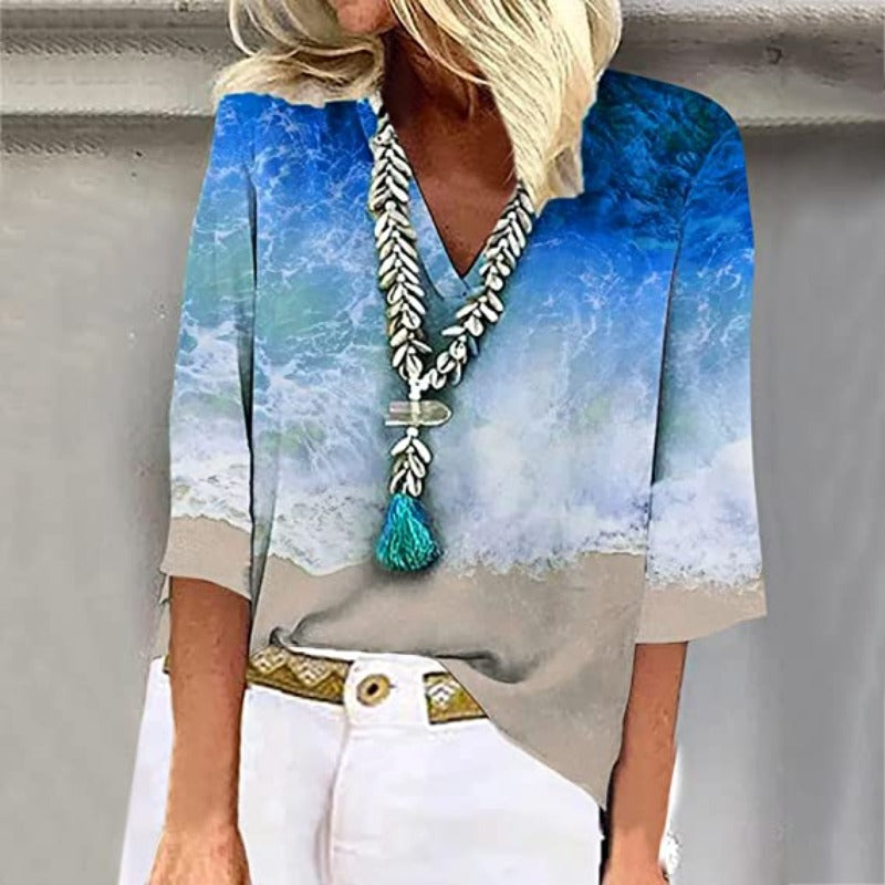 Detail van de elegante, luchtige damesblouse met kristalblauwe nuances en zandtinten.