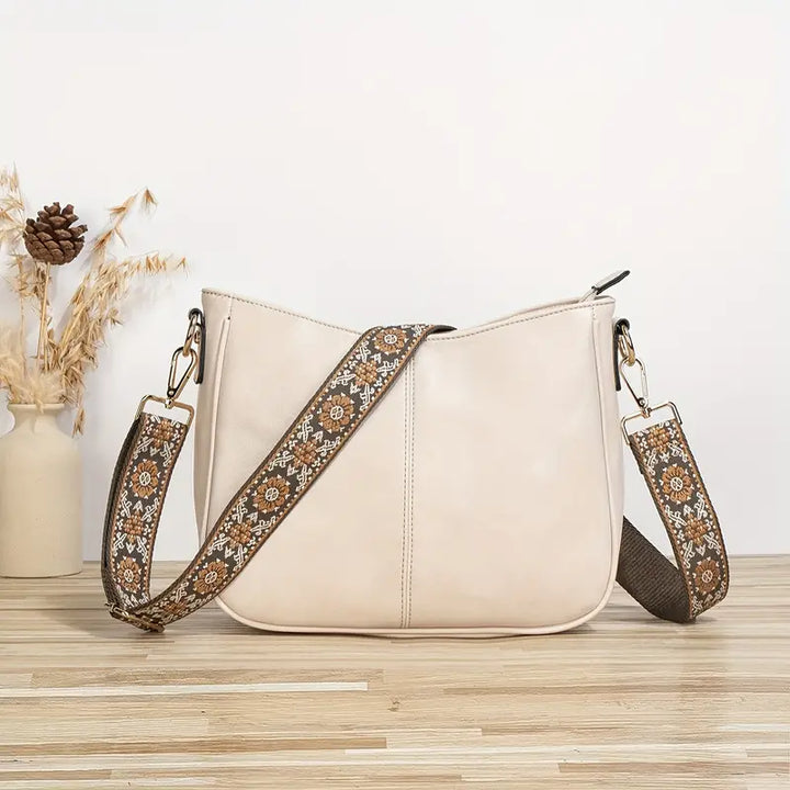 Elegante Quirina schoudertas in bohemien stijl met verstelbare riem en gouden details, vooraanzicht