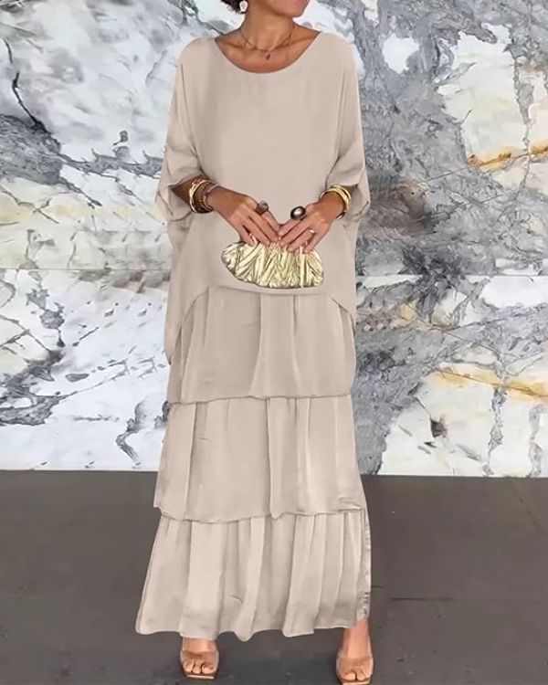 Zijkant van de Evelyn chiffonjurk, toont het vloeiende ontwerp en de elegante valling van de stof.