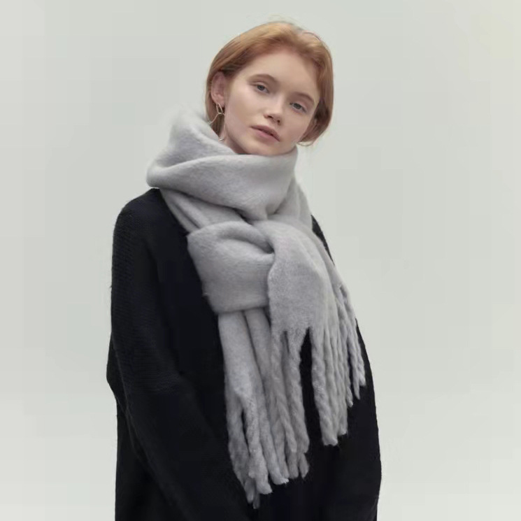 Elegante damessjaal met kwastjes van zachte stof, veelzijdig en warm, verkrijgbaar in bruin, grijs, zwart en wit.