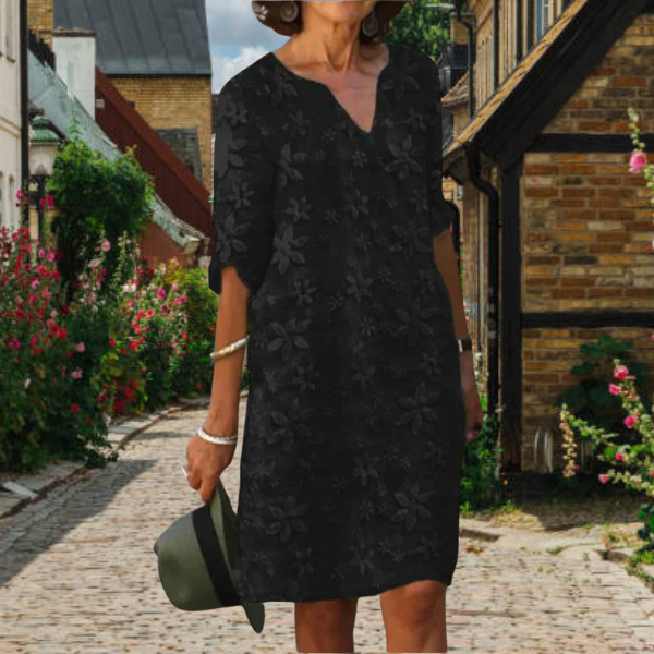 Achterkant van de elegante damesjurk met bloemenprint, 3/4 mouwen en een flatteuze pasvorm.