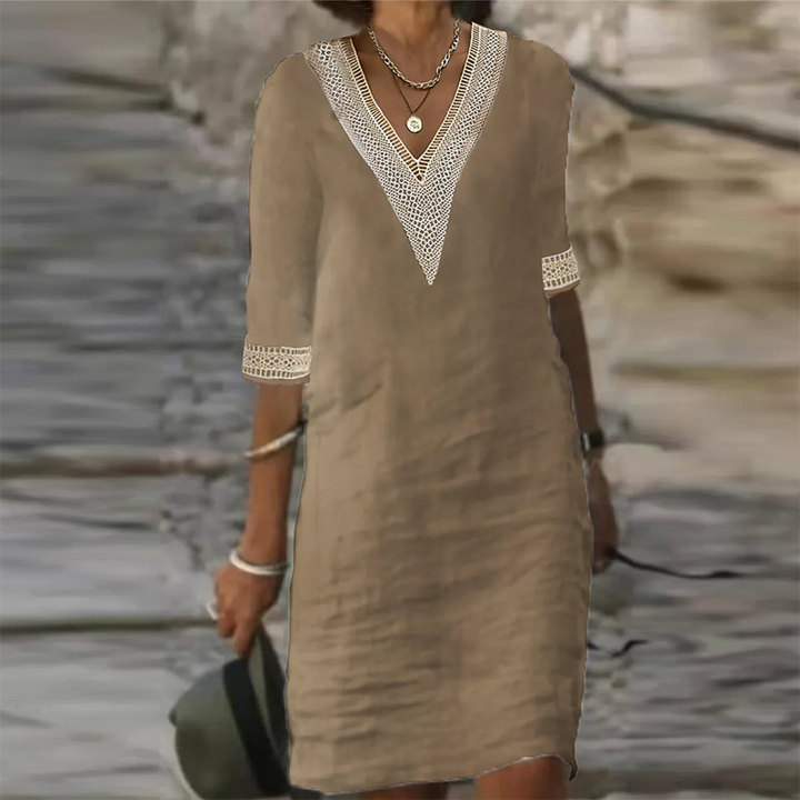 Zijaanzicht van de elegante witte linnen zomerjurk voor dames.
