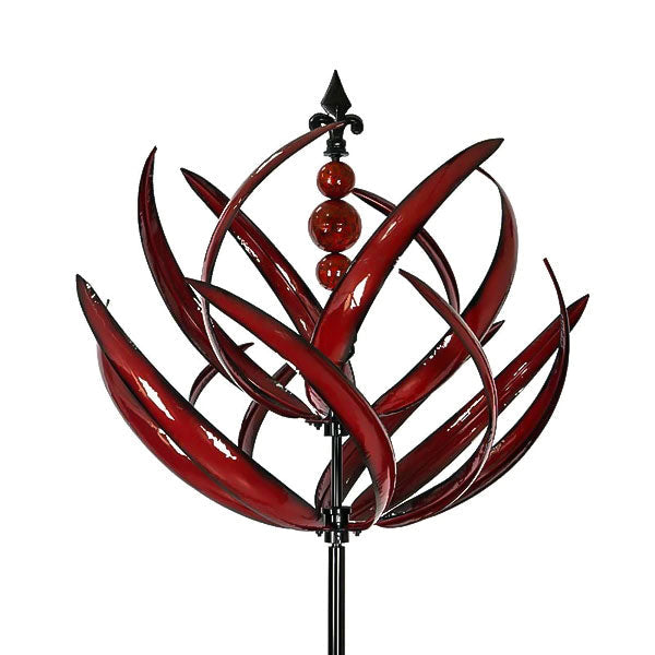 De rode metalen windspinner in volle rotatie