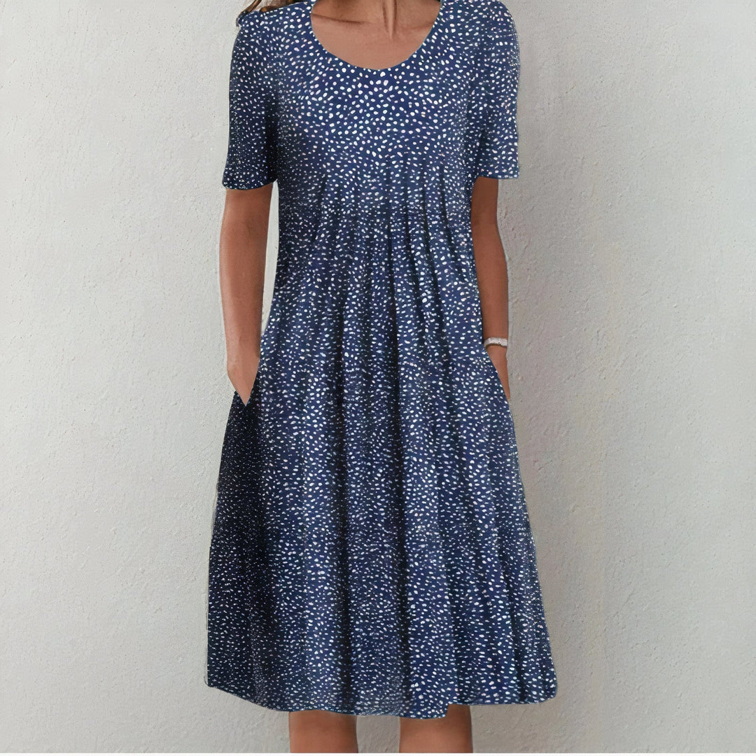 Elegant wit katoenen zomerjurk voor dames, knielengte en soepel vallend, ideaal voor elegante zomerse gelegenheden.