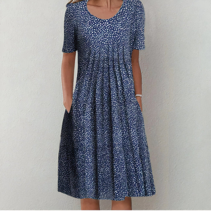 Elegant wit katoenen zomerjurk voor dames, knielengte en soepel vallend, ideaal voor elegante zomerse gelegenheden.