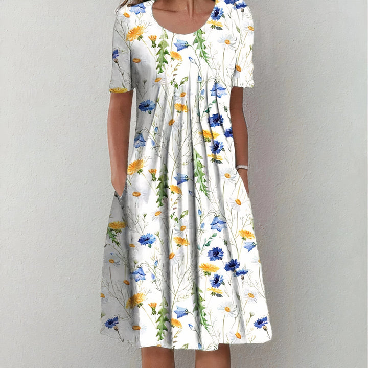 Elegant wit katoenen zomerjurk voor dames, knielengte en soepel vallend, ideaal voor elegante zomerse gelegenheden.