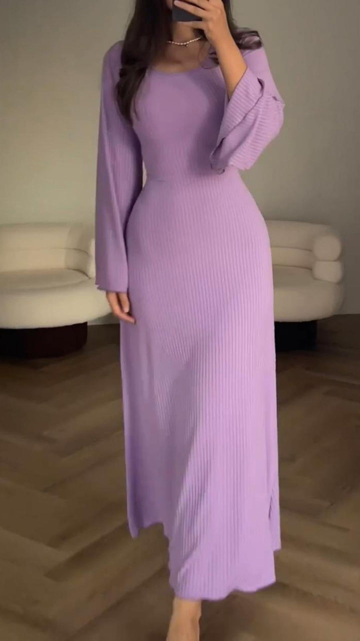 Achterkant van de vloeiende dames maxijurk, met focus op de elegante val van de stof.