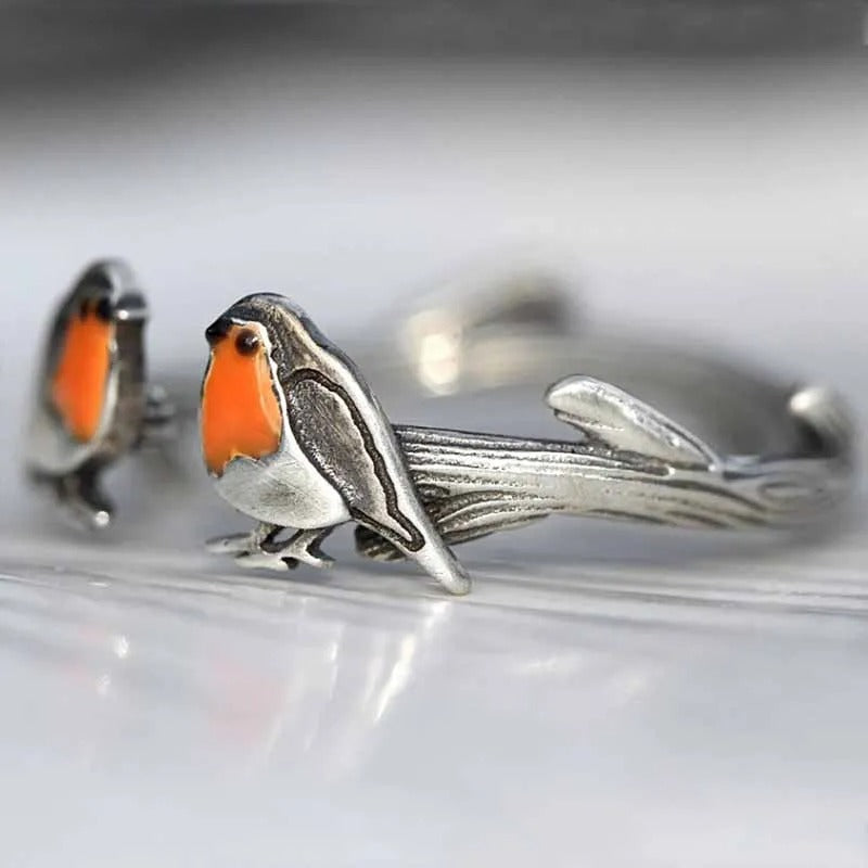 Glanzende roodborstje geluksvogel ketting en delicate oorbellen, een complete sieradenset.