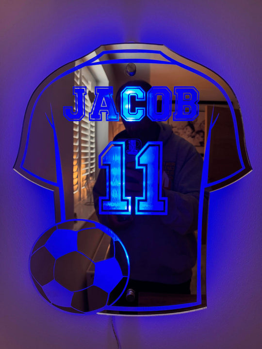 Voetbalshirt spiegel met eigen naam en rugnummer, verlicht door sfeervolle LED-verlichting. Sportieve wanddecoratie.