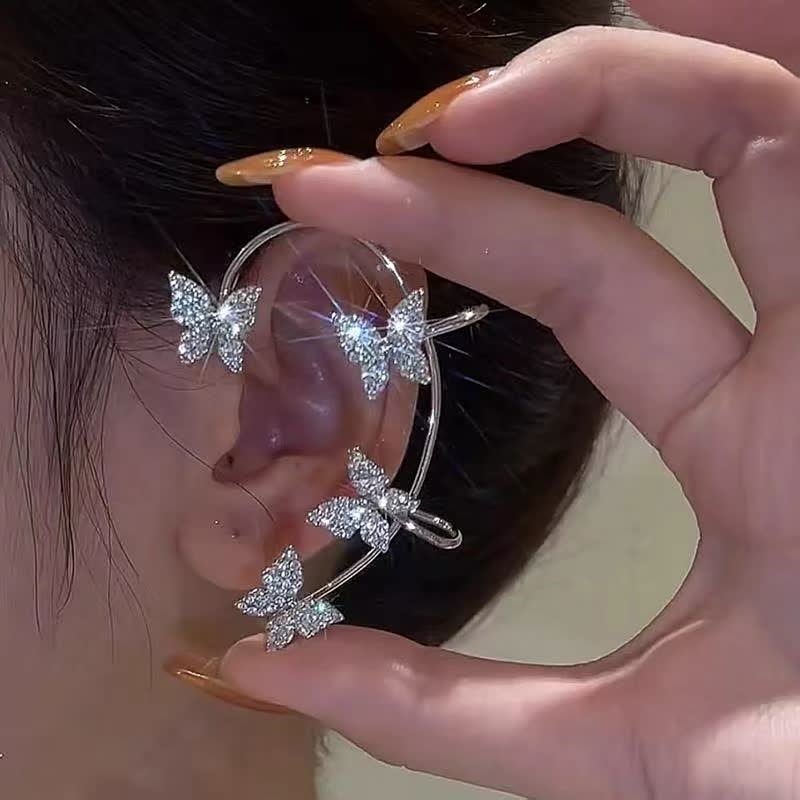Close-up van vlinder oorclip met glinsterende steentjes, een chic sieraad voor dames zonder oorgaatjes.