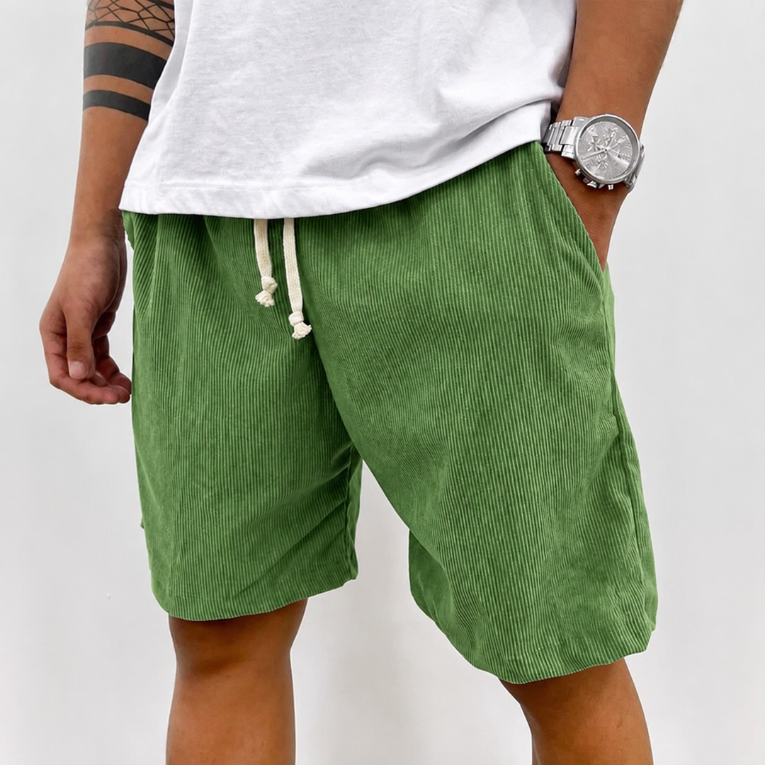Man zit casual in een relaxte houding, draagt de veelzijdige heren shorts