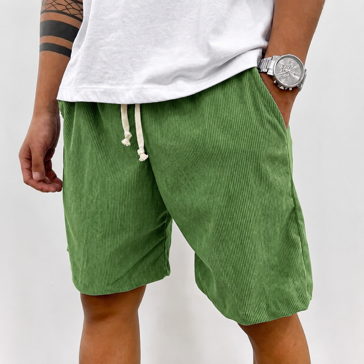 Man zit casual in een relaxte houding, draagt de veelzijdige heren shorts